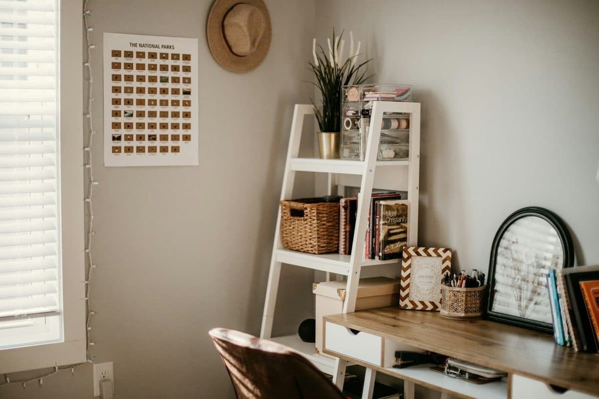 Small room organized with a ladder shelf, a woven basket, books, and a tidy desk